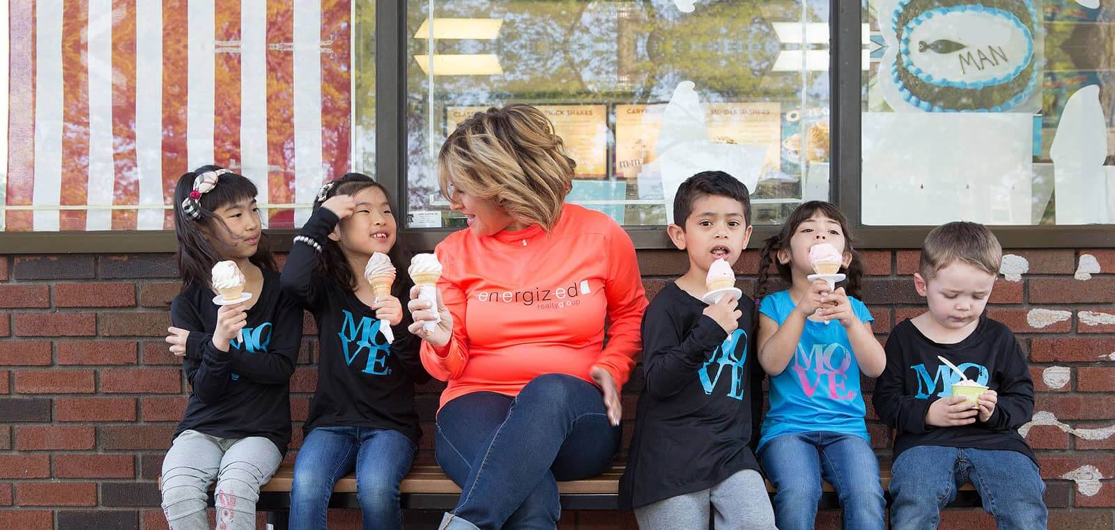 Judy Markowitz with five kids eating vanilla ice cream sitting in a bench outside the ice cream store